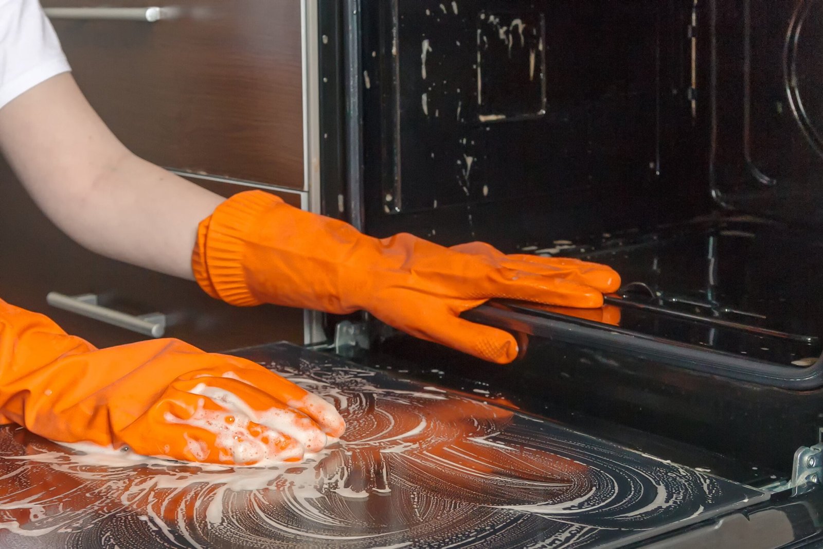 Kitchen cleaning.home cleaning, Girl's hands in gloves wash clean the stove, kitchen oven in the kitchen.